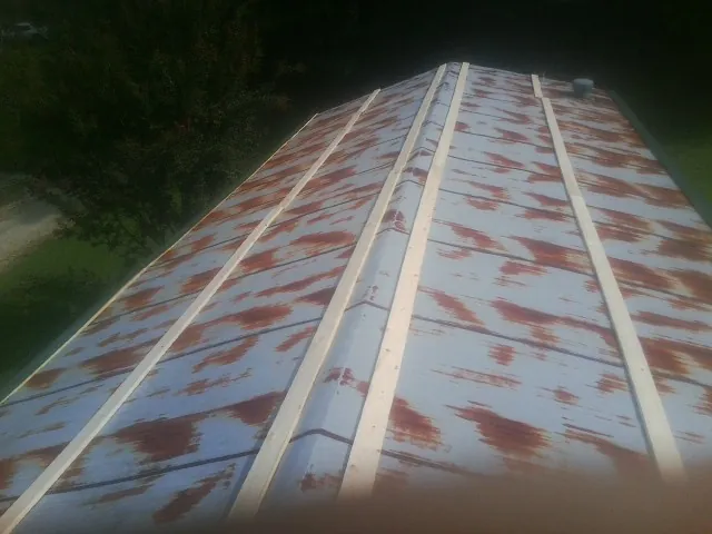 Rusted metal roof panels with new wood purlins before replacement — Storm Damage Roof Repair in Flintville by Roofing Brothers