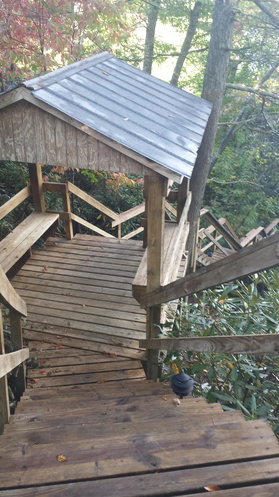 Metal roofed shelter over wooden steps on a wooded walkway — Skylight Repair & Installation work by our crew in Flintville