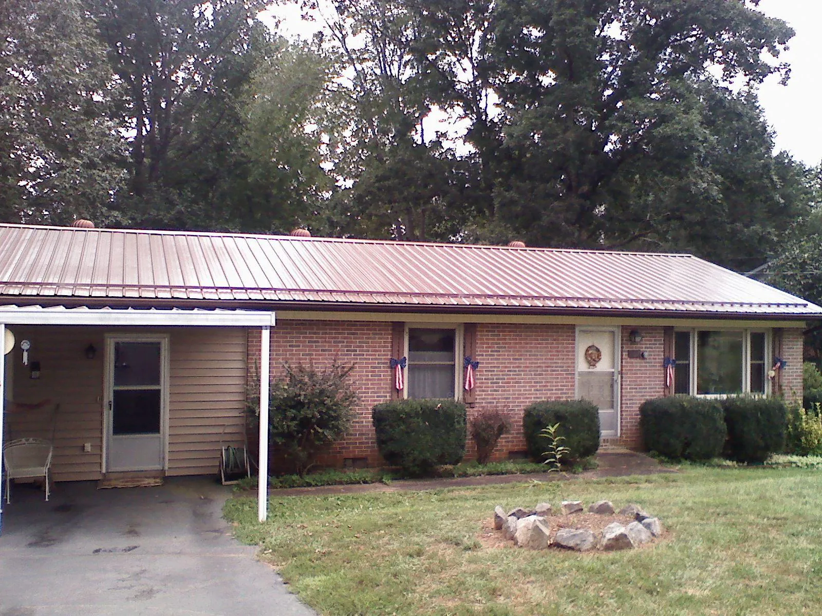 Bronze metal roof and carport on a brick ranch home — Roof Repair work by our crew in Flintville
